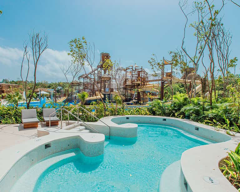 Jacuzzi con camastros en Jungala Aqua Experience, con vista a la zona de toboganes