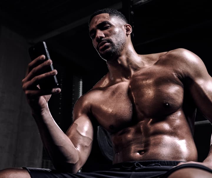 gym-man-checking-workout-phone.jpg
