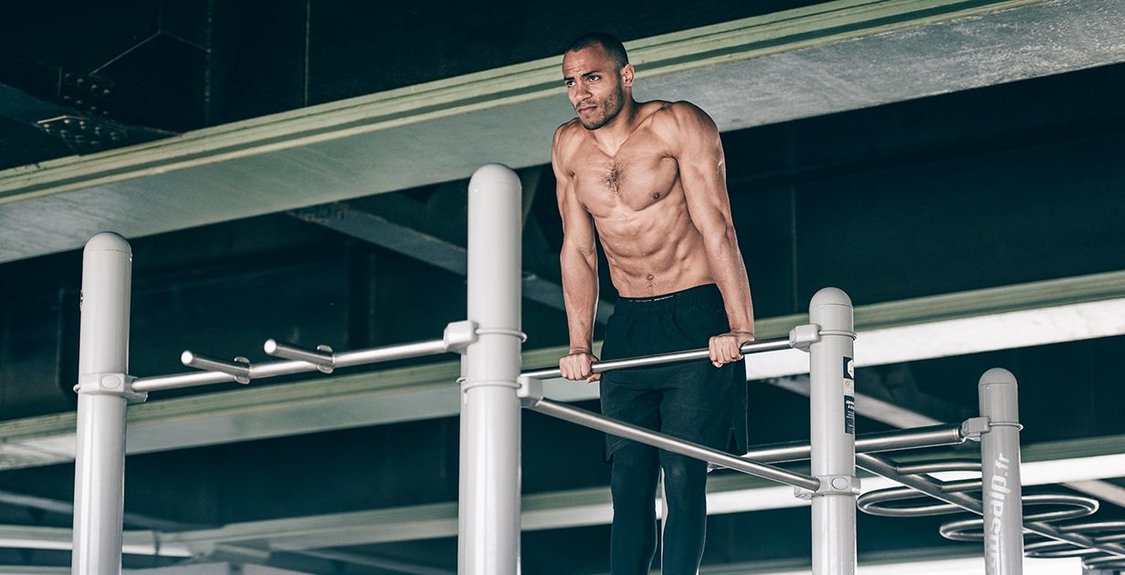 Male athlete performing dips