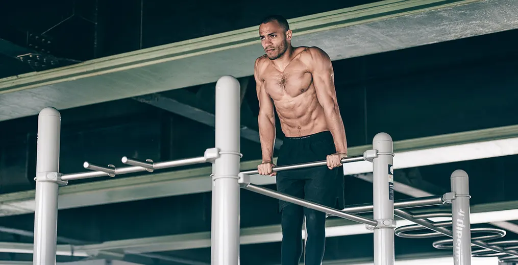Male athlete performing dips