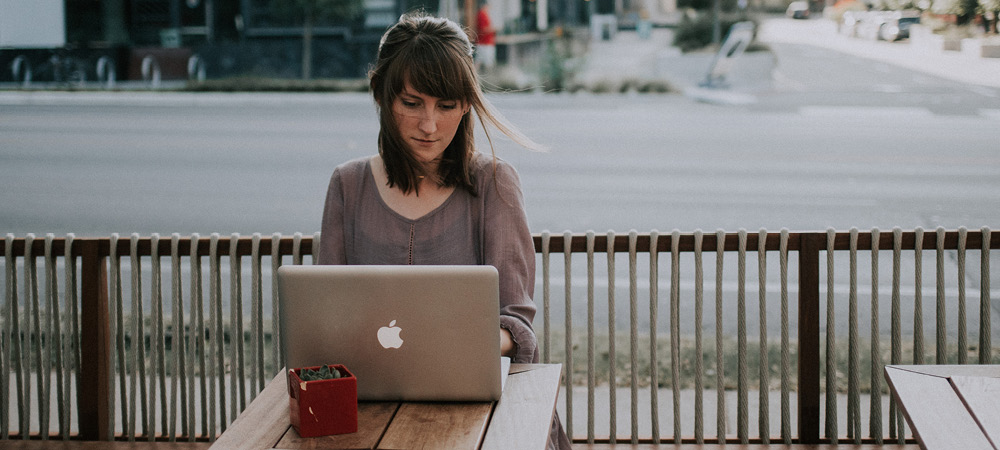 Femme travaillant sur son ordinateur à la terrasse d'un café