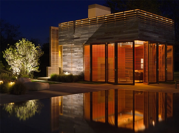 wood bifold door at night over a pool