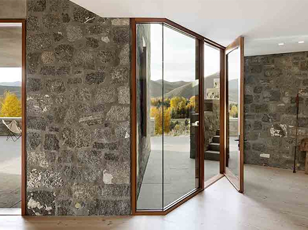 wood in-swing door on a rock wall home interior