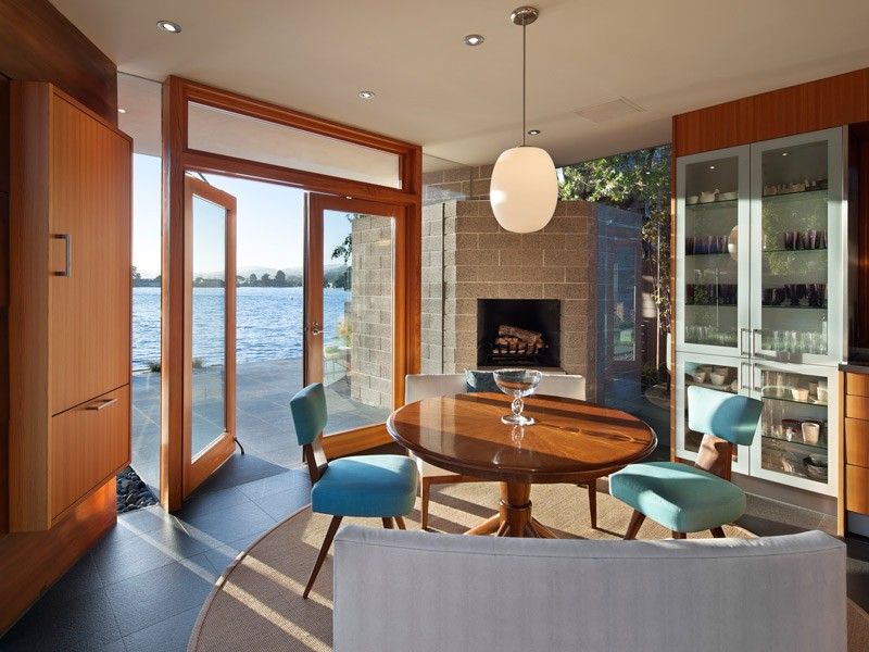 Ocean view through a slightly opened wood outswing casement door in a modern living and dining room