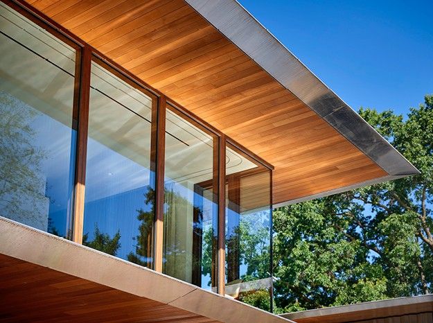 The edge of a modern building with storefront windows near trees