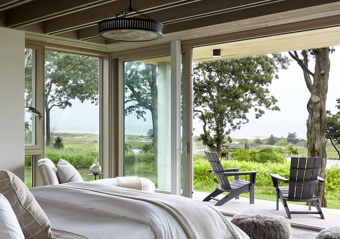 tropical bedroom with lift-and-slide doors open to the outside