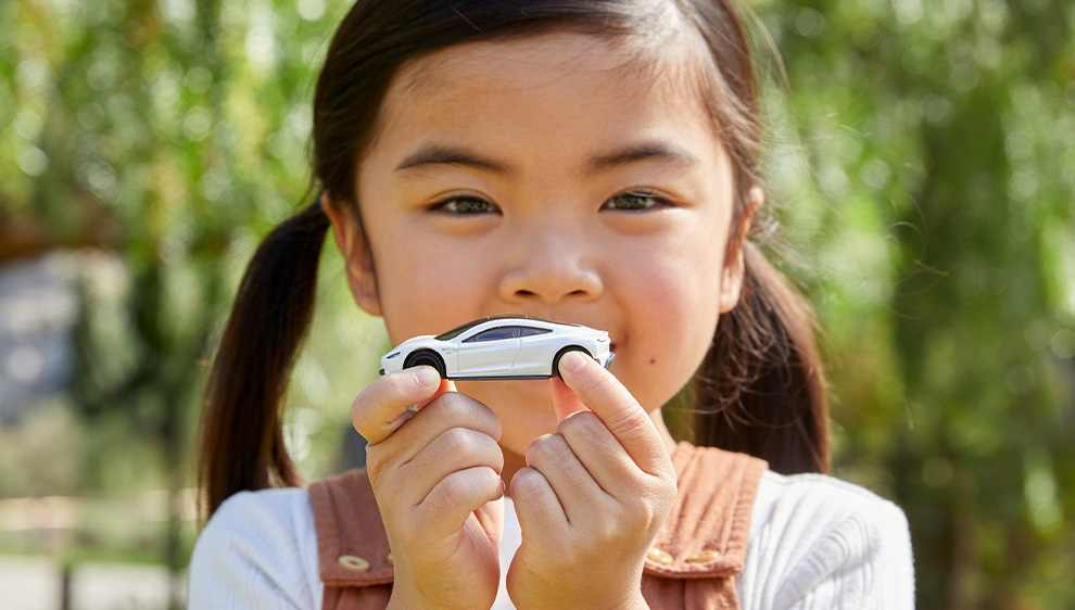 little girl with Matchbox Tesla