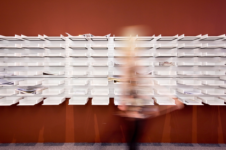 Person walking in front of mail holders.