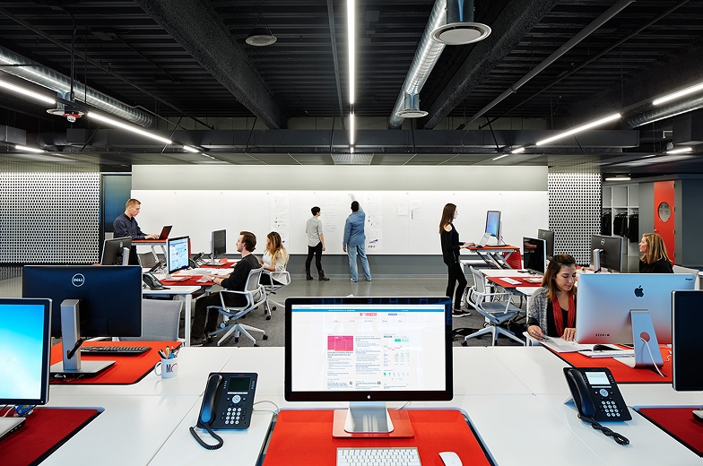 View of open plan office with people at desks.
