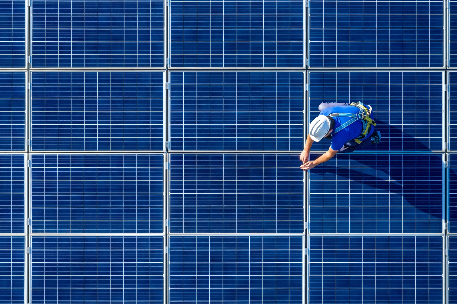 Aerial view of a technician on solar panels.