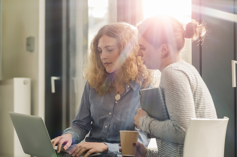 Two people working at desk.