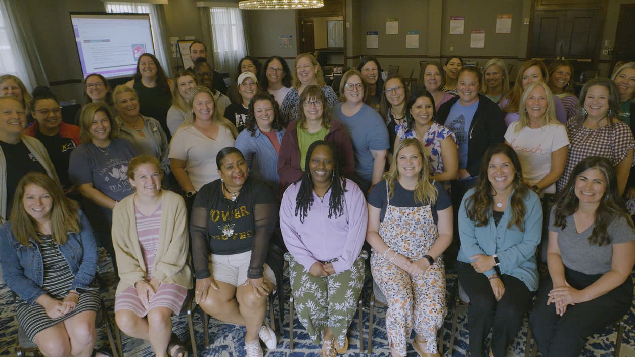 Group photo in a conference room with participants seated and standing, facing the camera. Group photo in a conference room with participants seated and standing, facing the camera.