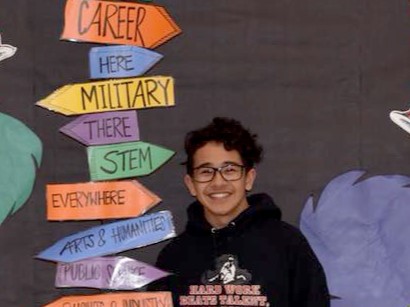Scholar standing in front of a colorful signpost featuring various educational and career pathways.