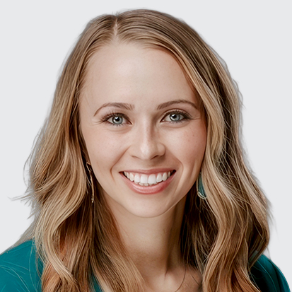 A person with long wavy blonde hair, wearing a teal top against a neutral background.