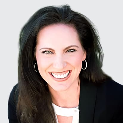 Person sitting outdoors with long brown hair wearing a black blazer and white blouse. Person sitting outdoors with long brown hair wearing a black blazer and white blouse.