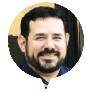 A person with short dark hair wearing a dark shirt. A person with short dark hair wearing a dark shirt.