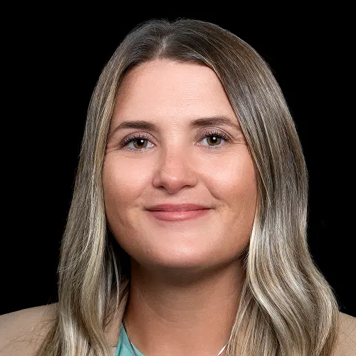 A portrait image showing a person with long, light brown hair, wearing a teal top against a black background. A portrait image showing a person with long, light brown hair, wearing a teal top against a black background.