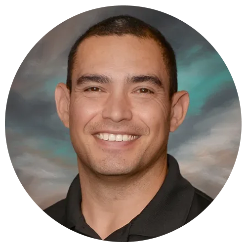 A person wearing a black collared shirt, set against a background with green and grey hues.