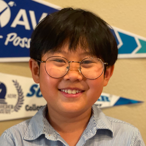 Person wearing a striped shirt with colorful banners in the background.
