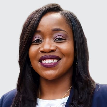 Portrait photo of a person with long, dark hair wearing a dark blazer and a white shirt with decorative elements. Portrait photo of a person with long, dark hair wearing a dark blazer and a white shirt with decorative elements.