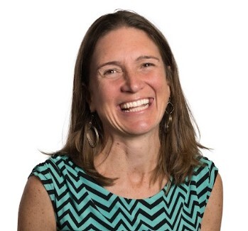 Person with shoulder-length hair wearing a zigzag pattern top.