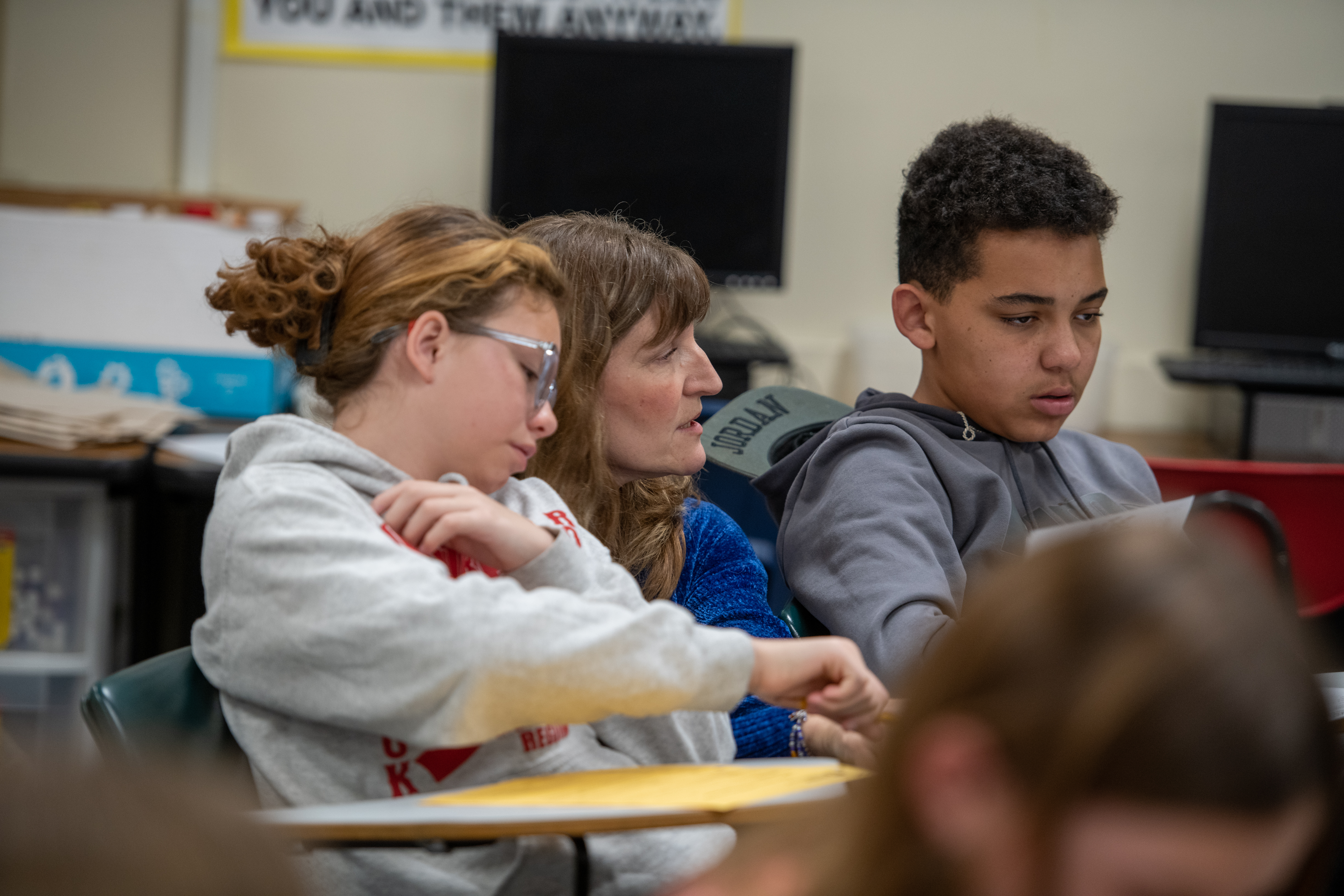 Students sitting in a classroom, engaging in activities and discussion.