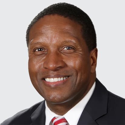 A person in a business suit with a white shirt and red-striped tie. A person in a business suit with a white shirt and red-striped tie.