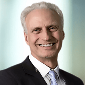 A person dressed in a suit and tie with a light background. A person dressed in a suit and tie with a light background.