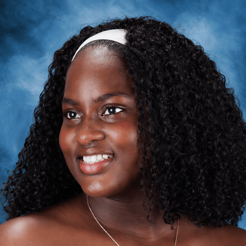 Person with curly hair, wearing a white headband, against a blue background. Person with curly hair, wearing a white headband, against a blue background.
