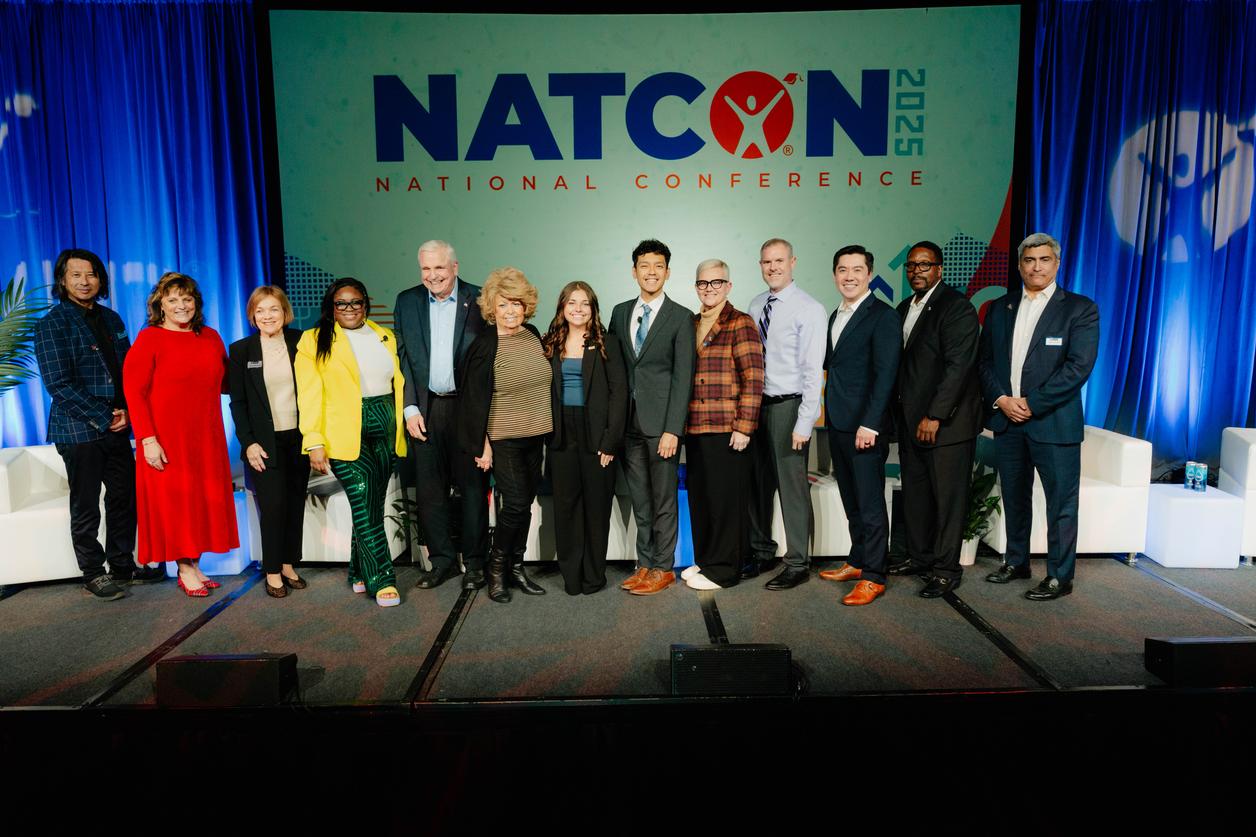 Group of eleven people standing on stage at the NatCon 2025 National Conference. Group of eleven people standing on stage at the NatCon 2025 National Conference.
