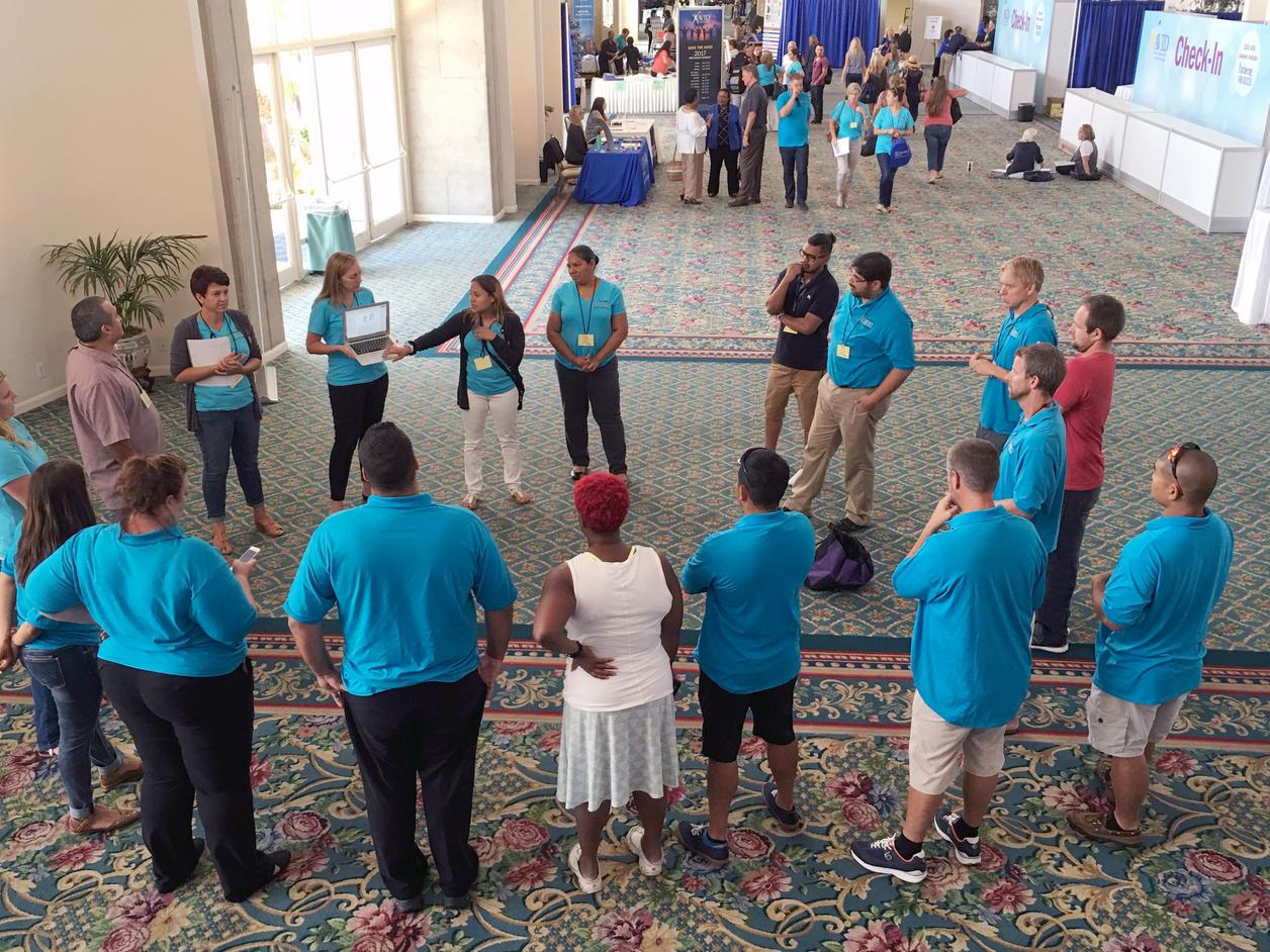 A group of people standing in a circle during a conference or meeting. A group of people standing in a circle during a conference or meeting.