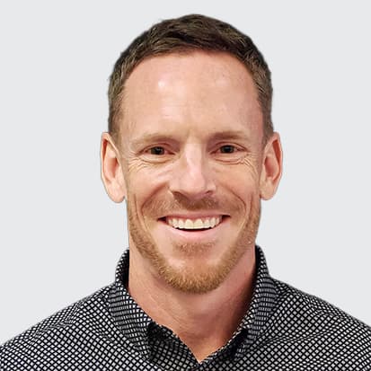 A close-up of a person wearing a checkered shirt, photographed against a black background. A close-up of a person wearing a checkered shirt, photographed against a black background.