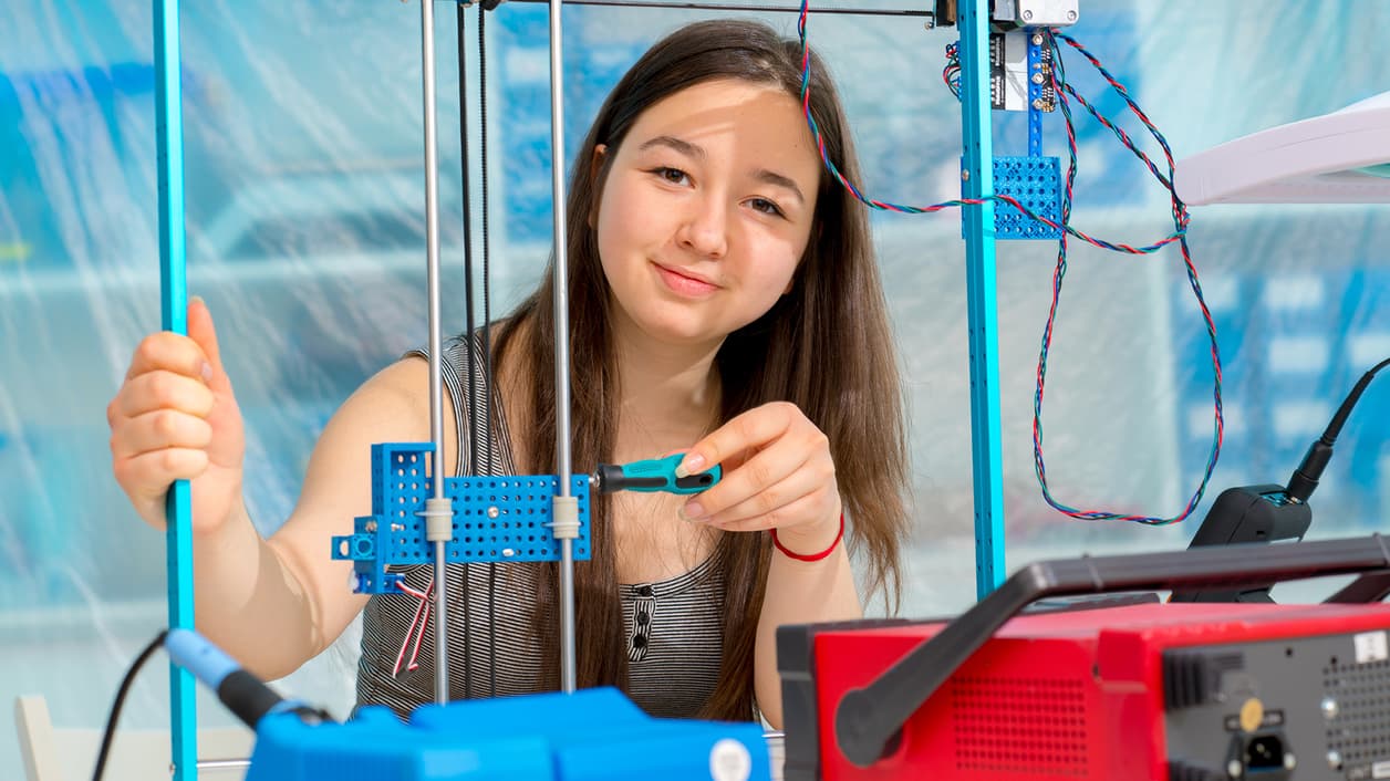 Person working on a blue mechanical project with tools. Person working on a blue mechanical project with tools.
