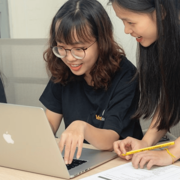 Two individuals collaborating on a laptop, one pointing at the screen with a pencil. Two individuals collaborating on a laptop, one pointing at the screen with a pencil.