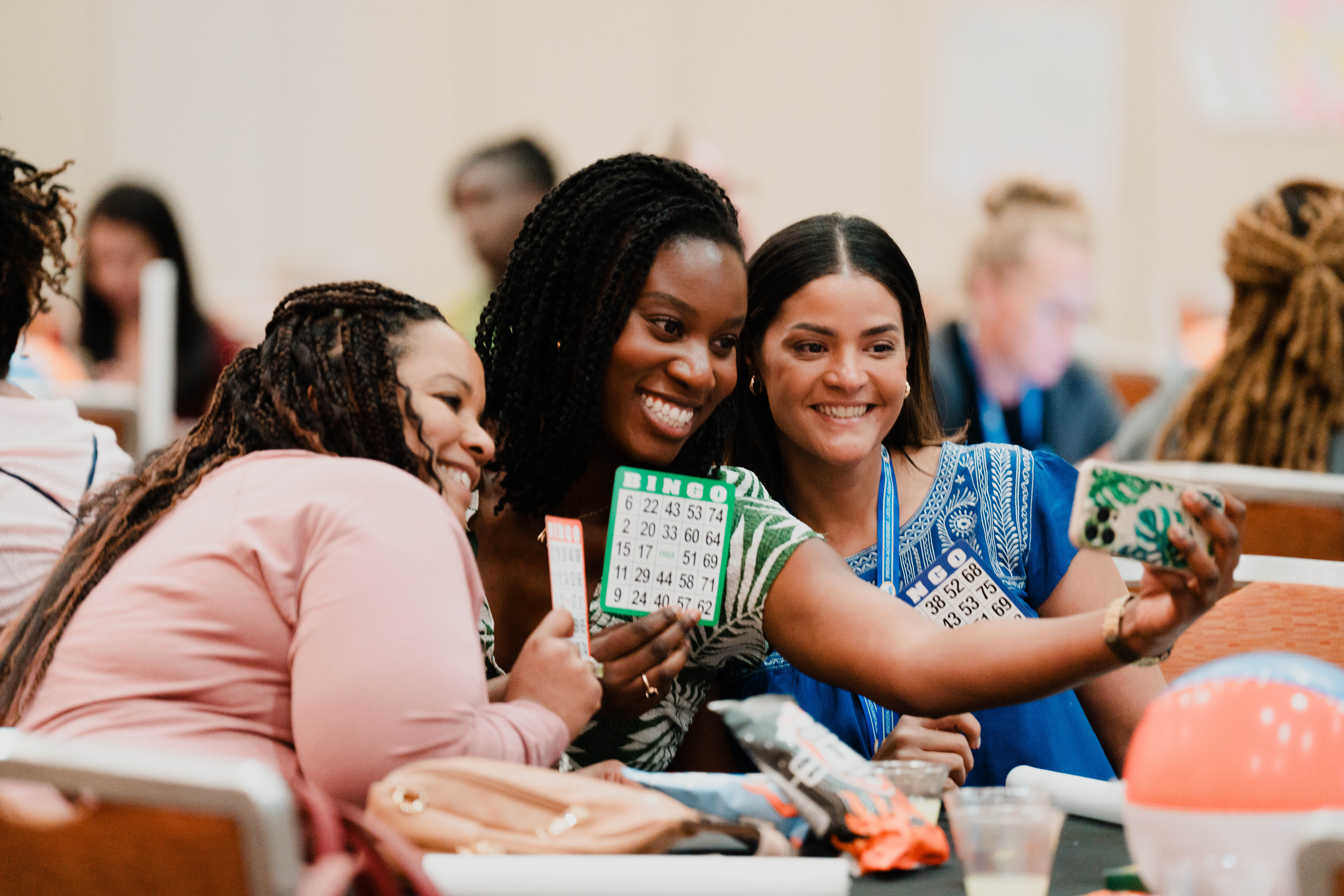 Group of people playing bingo and taking a selfie at a social event.