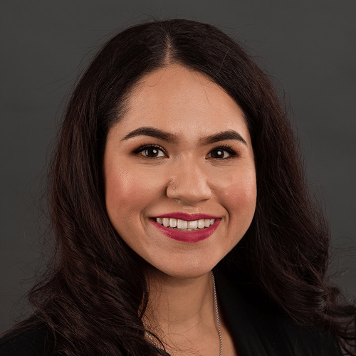 Photograph of a person with long, curly dark hair, wearing a black top against a dark background. The face is censored. Photograph of a person with long, curly dark hair, wearing a black top against a dark background. The face is censored.