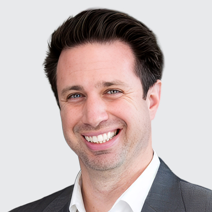 A person wearing a suit and white collar shirt with a blurred face.