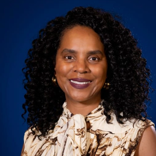Person with curly hair wearing a patterned scarf, set against a blue background.