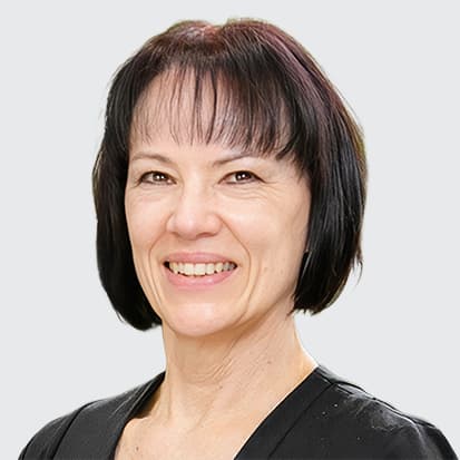 A portrait photo with a blurred face, featuring a person with shoulder-length, dark hair and wearing a black top. The background consists of green plants giving a natural ambiance. A portrait photo with a blurred face, featuring a person with shoulder-length, dark hair and wearing a black top. The background consists of green plants giving a natural ambiance.