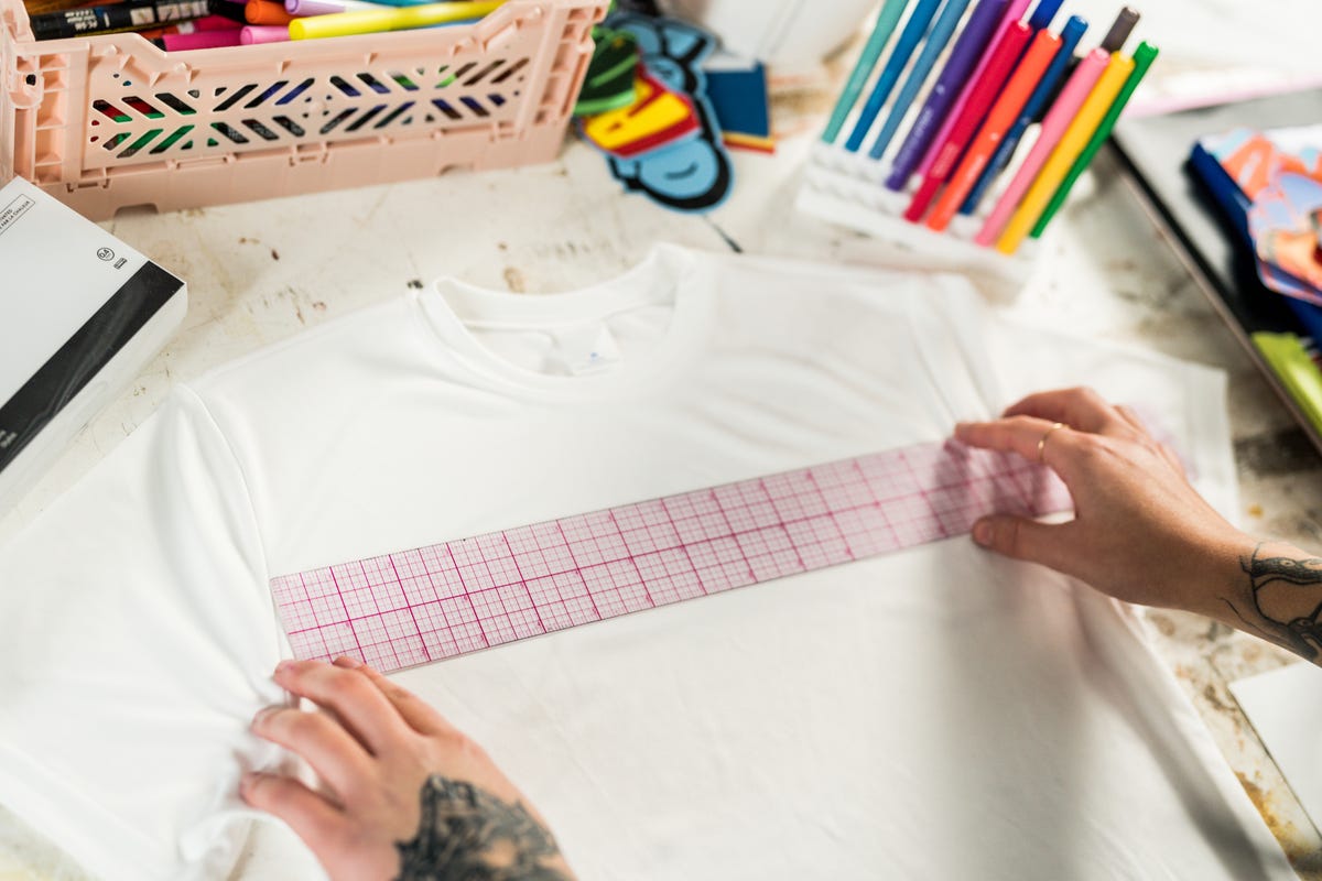 Acrylic ruler on a blank white t-shirt to map out a design.