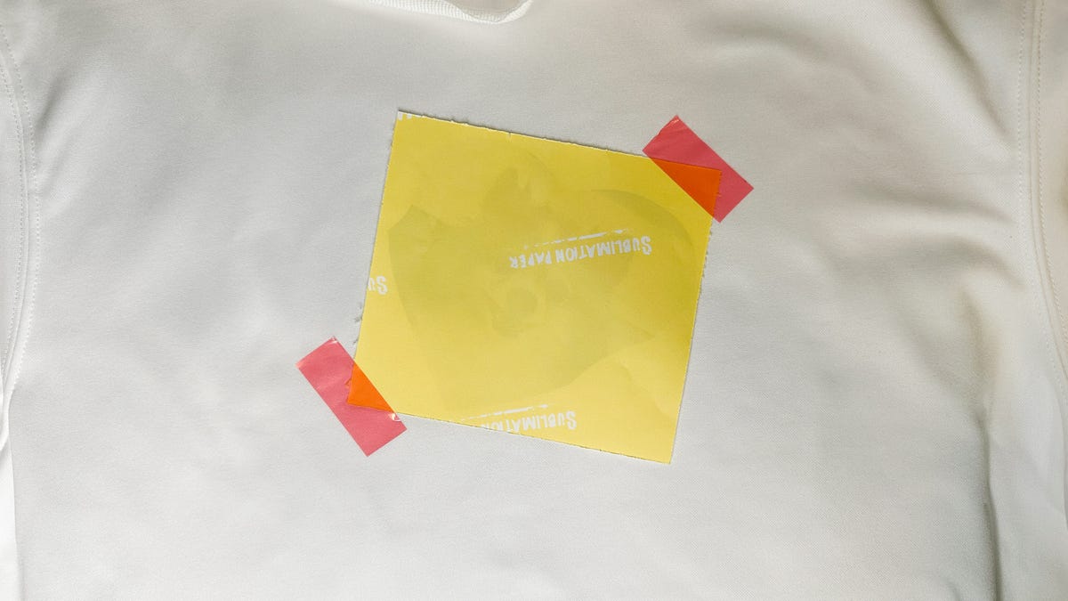 Image of a Pomeranian faced down with the yellow page up taped with red heat safe tape.