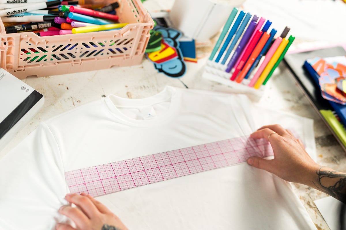 Using an acrylic ruler, map out the placement of the design on a white t-shirt.