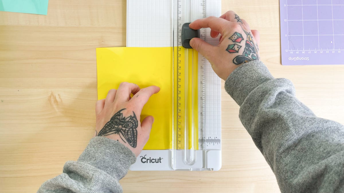 Using a straight-edge cutter to cut the heat transfer vinyl in equally sized strips.