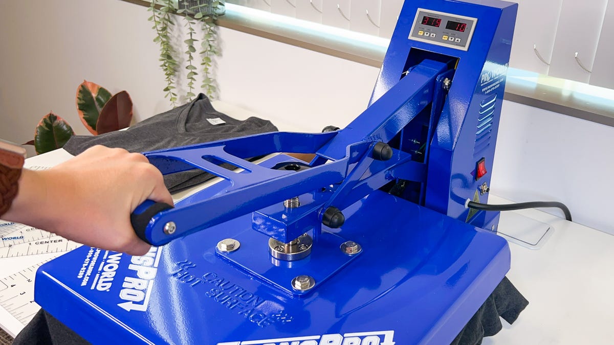 Close the clamshell heat press to press the design into the t-shirt.