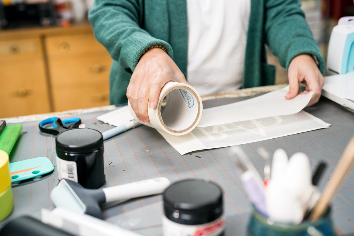 Jennifer adding the transfer tape onto the vinyl.