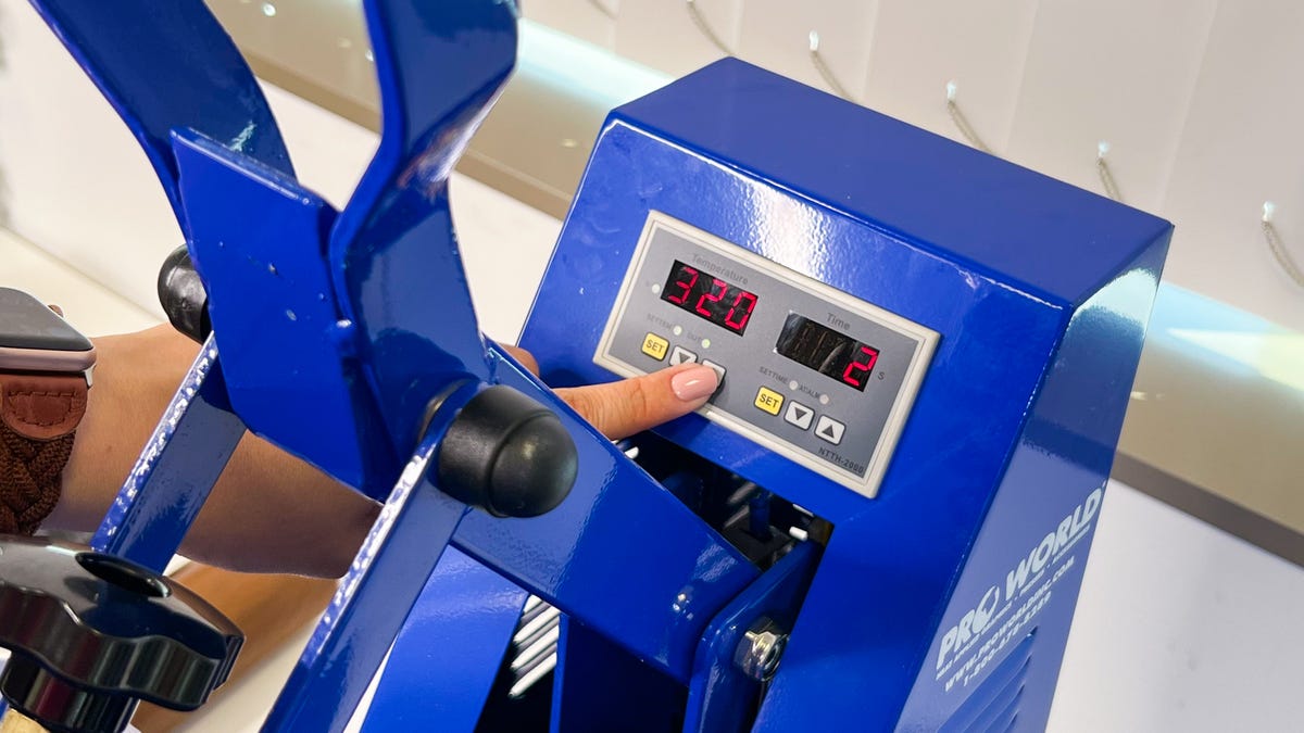 Setting the time and temperature on the clamshell heat press.