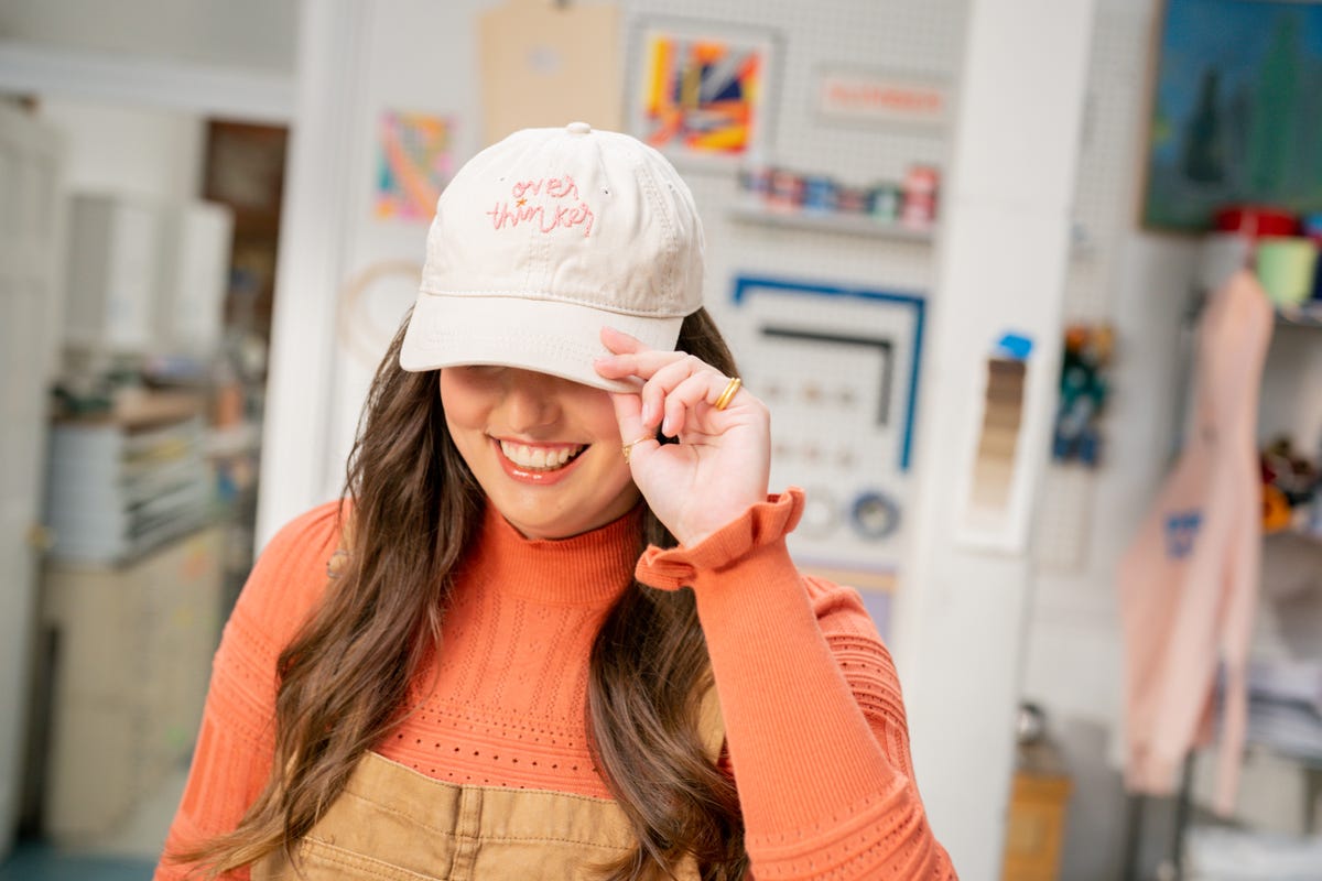 Sophie Nistico wearing an embroidered hat with the words "Over thinker" stitched.