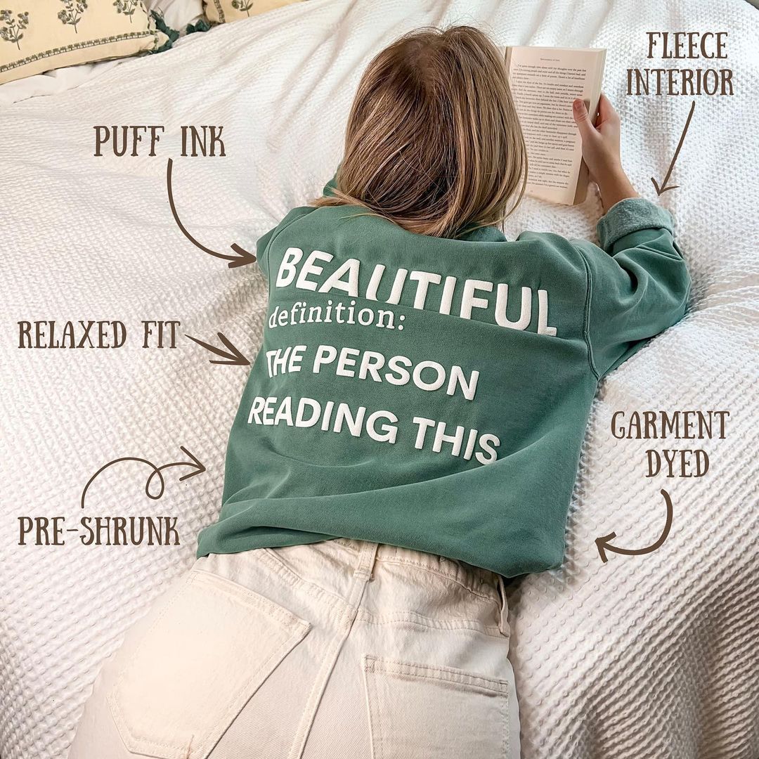 Photo of t-shirt with Beautiful definition: The Person Reading This printed in the back with labels about the t-shirt and the puffy ink used.