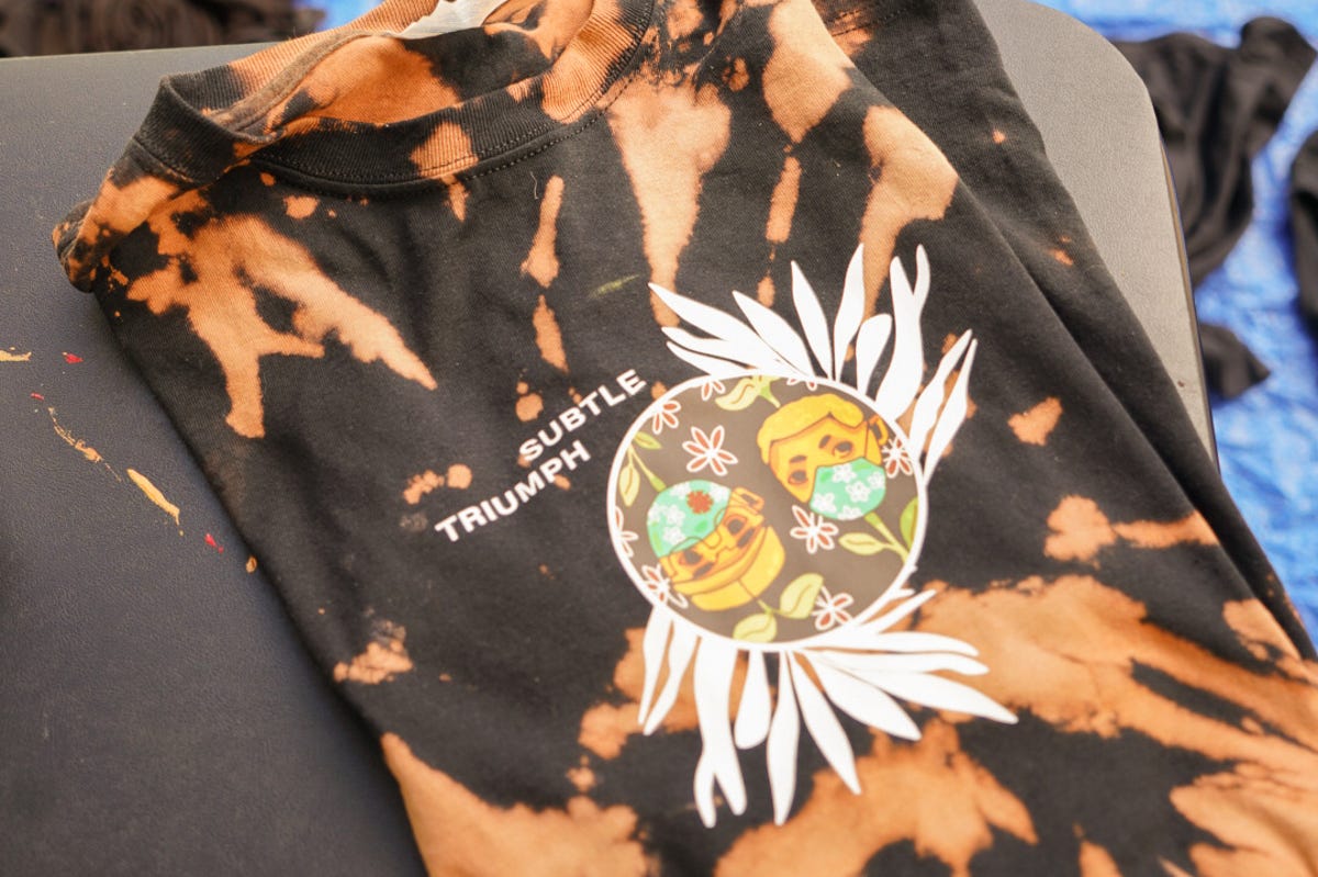Reverse bleach dyed black t-shirt with Subtle Triumph logo heat pressed on the front.