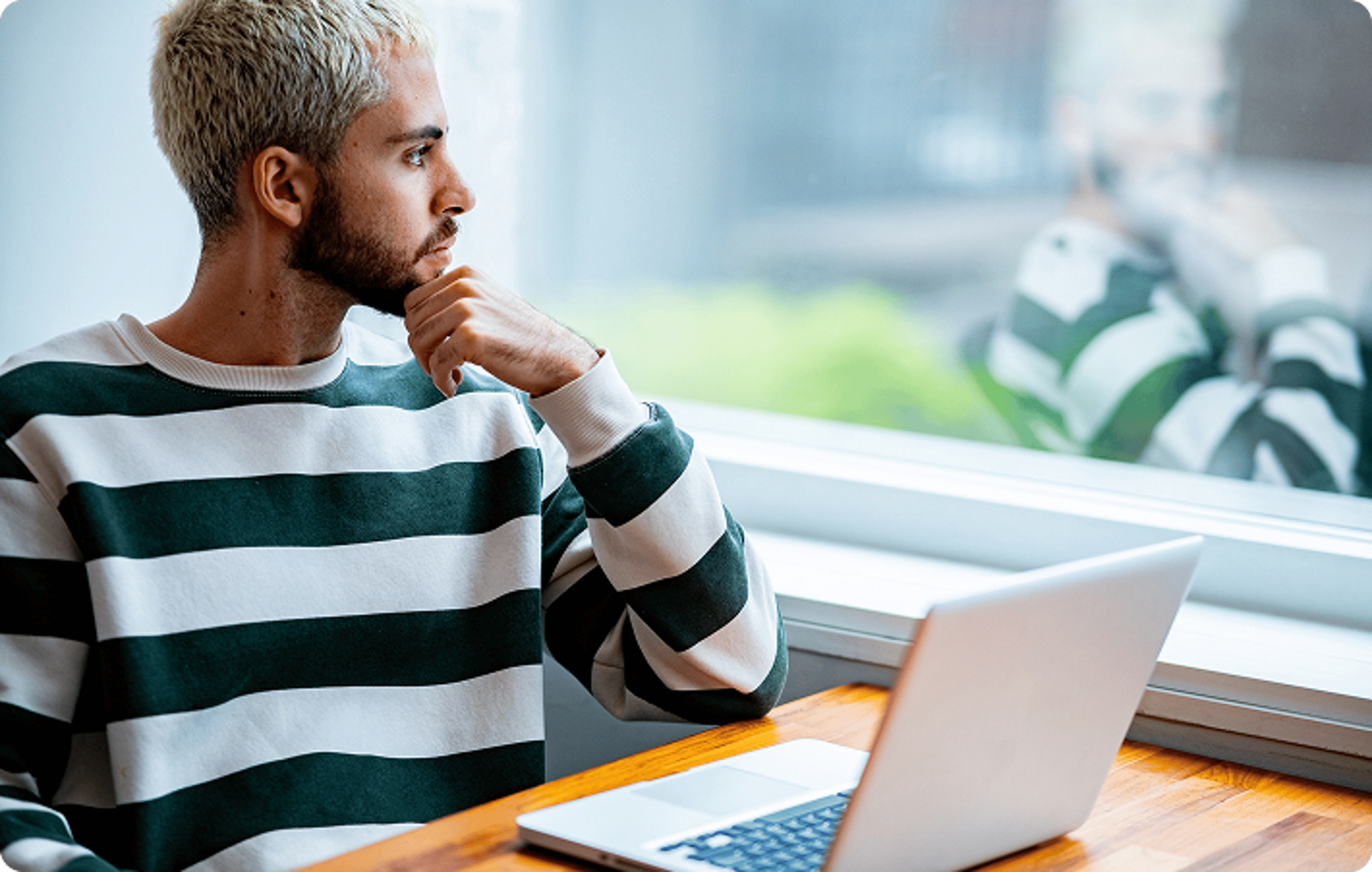 Man with his hand on his chin in front of laptop
